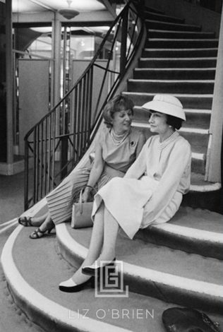Coco Chanel Sits on Stairs with Unidentified Woman, 1957 by Mark Shaw