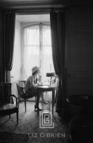 Coco Chanel Writes at Desk in Window, Head Up, 1957