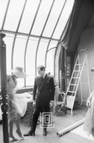 Dior designer Marc Bohan shown with a model in his salon, 1961