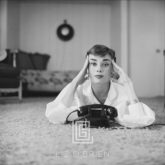 Audrey Hepburn in White Blouse with Phone, Laying, Fingers on Temples, 1953