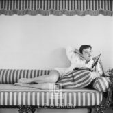Audrey Hepburn on Striped Sofa, Arm Back, Head Tilted, 1954