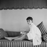 Audrey Hepburn on Striped Sofa, Leans Forward, 1954