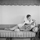 Audrey Hepburn on Striped Sofa, Elbow Behind Head, 1954